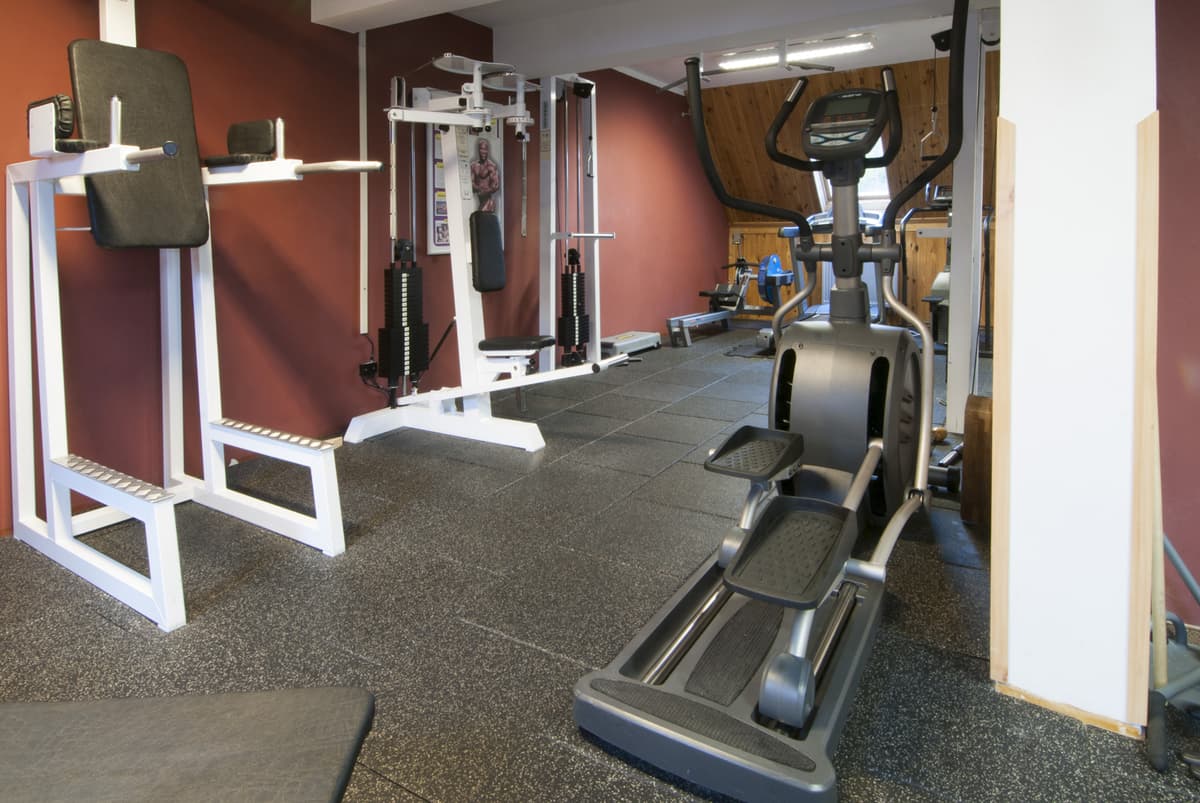 Der Hauptteil des Fitnessraums mit Rückenmaschinen und einem Cardio-Gerät.