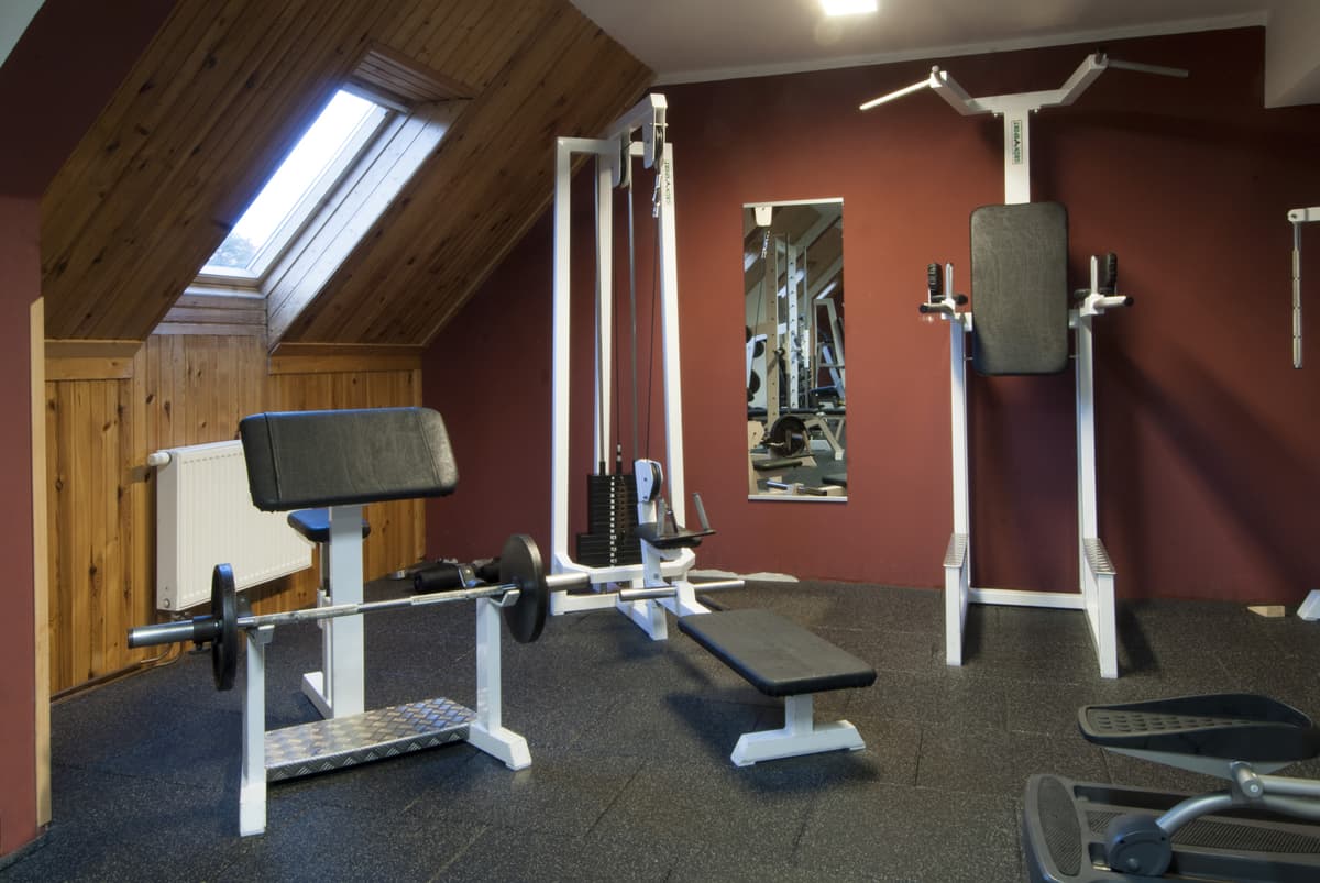 Blick auf den Fitnessraum mit Spiegeln und Trainingsgeräten.