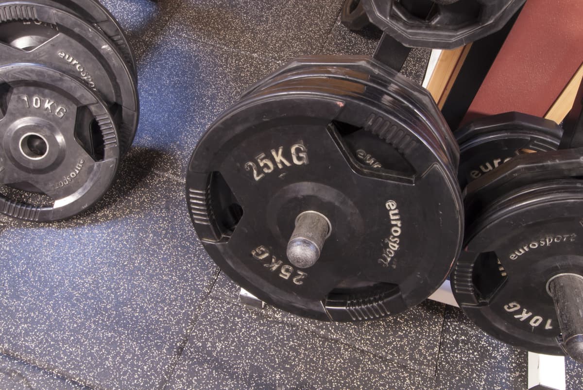 Detail von Hanteln und Gewichten, eines der Gewichte hat ein Gewicht von 2,5 kg.