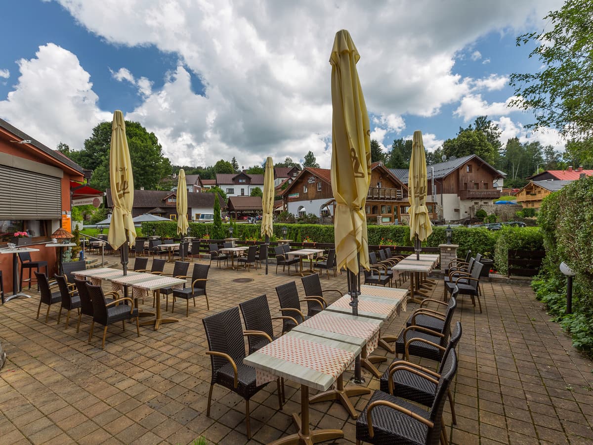 Terrasse mit gelben Sonnenschirmen und Dorfblick