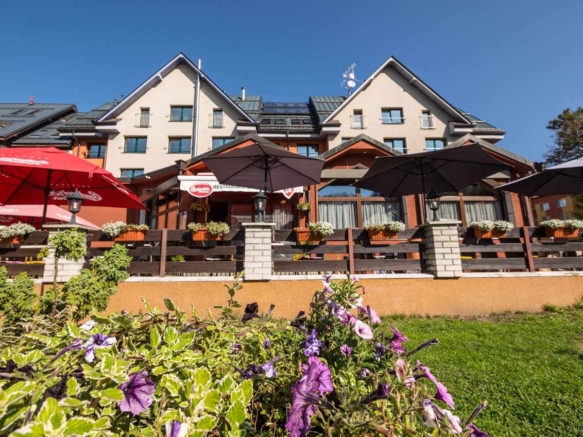 Sommerterrasse mit roten Sonnenschirmen und Blumen