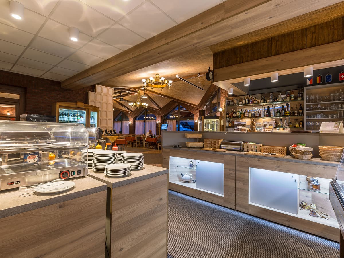 Blick auf das Buffet und die Bar im Restaurant mit Holzvertäfelung.