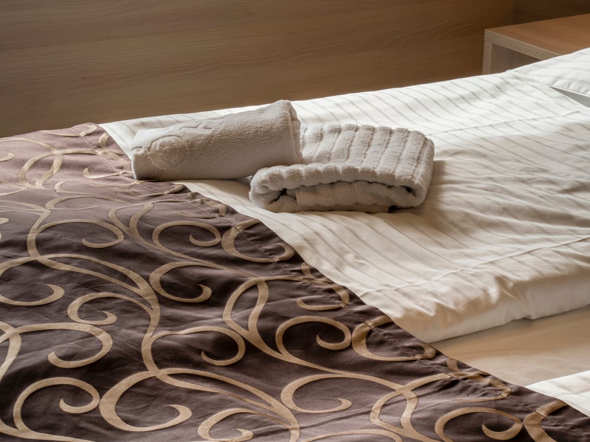 Folded towels on elegant bedding