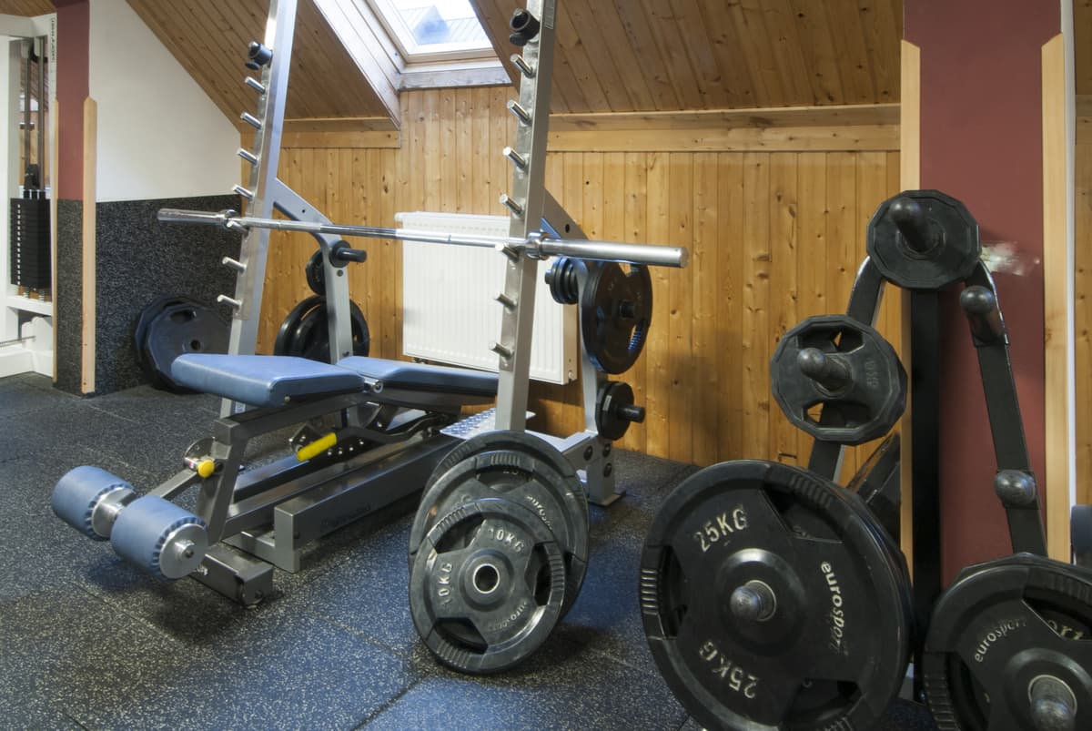 A rack with dumbbells, a weight bench and other equipment.