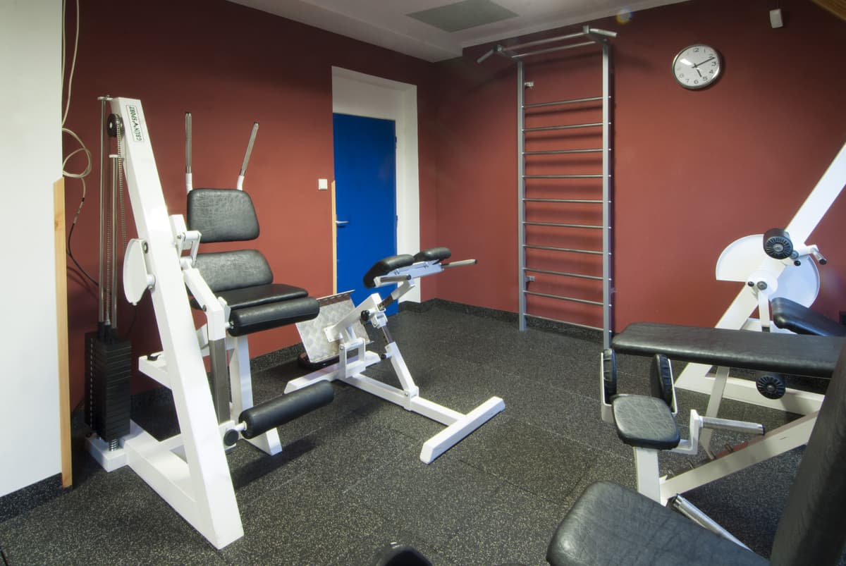 A weight bench and pull-up bar with wooden paneling.