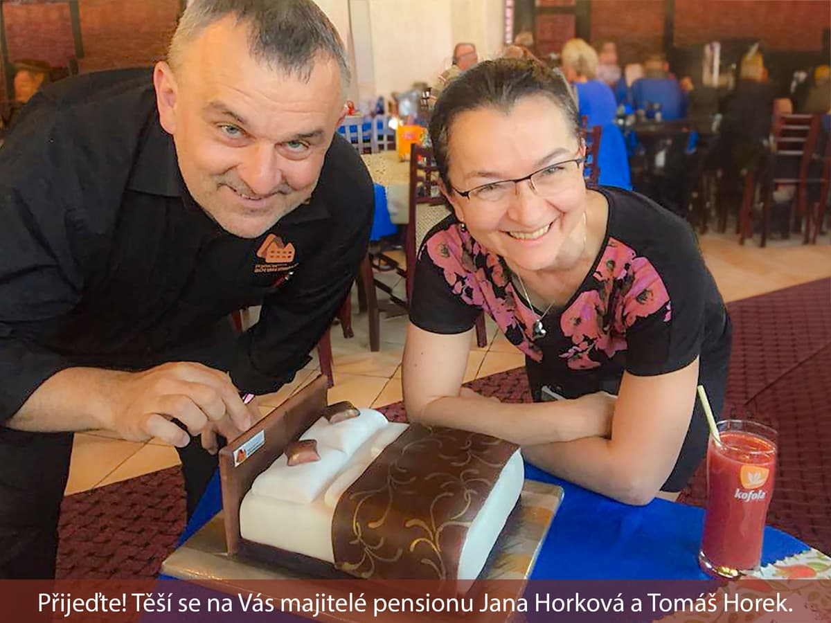 Two smiling people with a cake in a restaurant