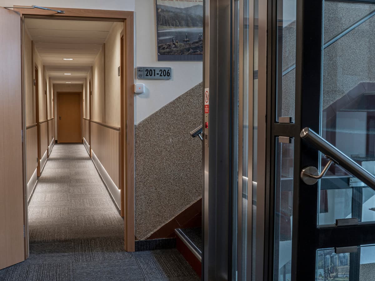 Hallway with elevator and room doors